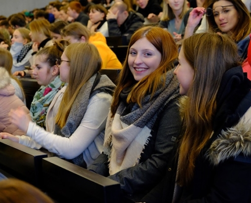 Schülerin im Hörsaal lächelt in die Kamera